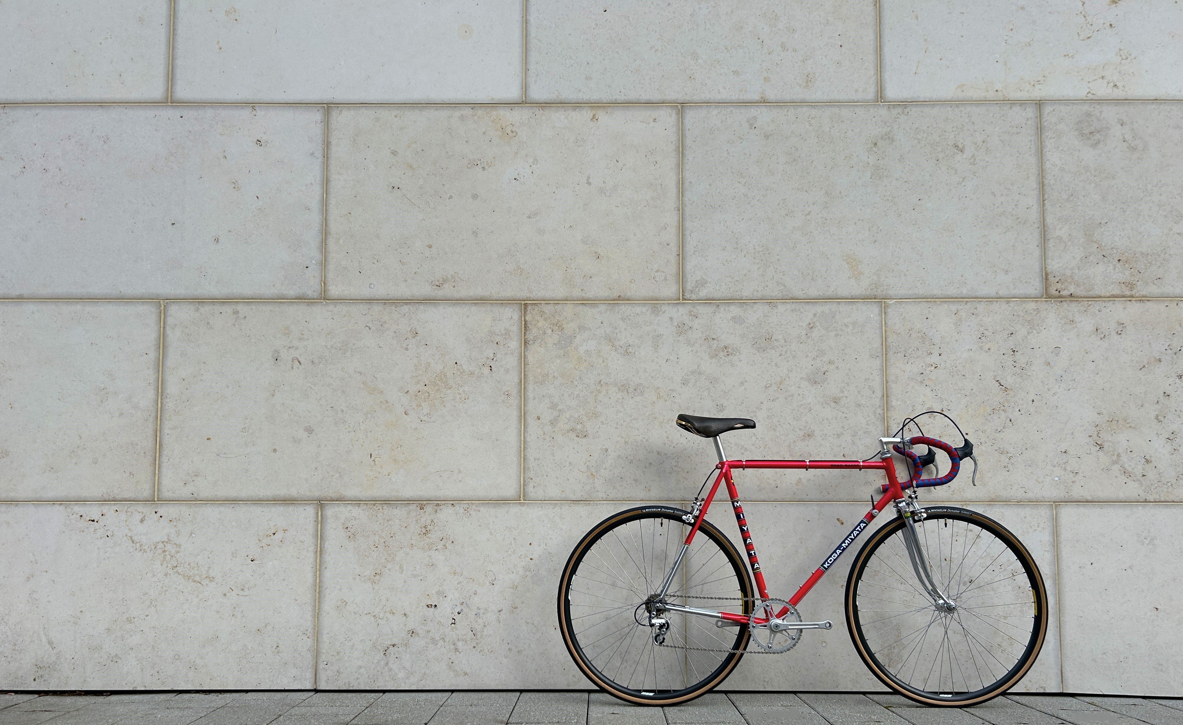 Very Nice red Koga Miyata Vintage Racing Bike from the 1980s leans against a jurassic limestone wall.